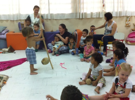 Criança brinca com berimbau recém contruído